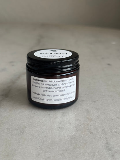 Back label of jar of Base Layer by Leopard Goods, 1.6oz, on a marble surface
