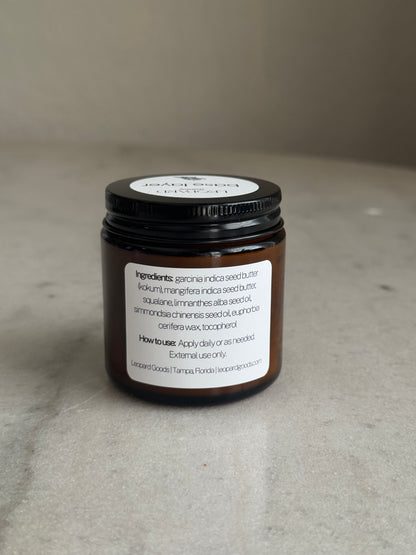 Back label of jar of Base Layer by Leopard Goods, 3.2oz, on a marble surface