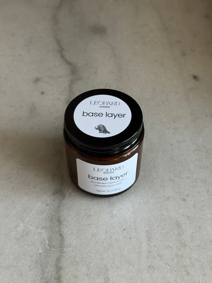 Overhead view of jar of Base Layer by Leopard Goods, 3.2oz, on a marble surface