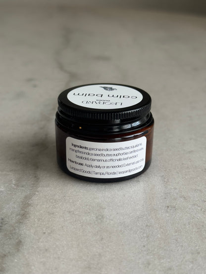 Back label of a 0.8oz jar of Calm Balm by Leopard Wellness on a marble surface
