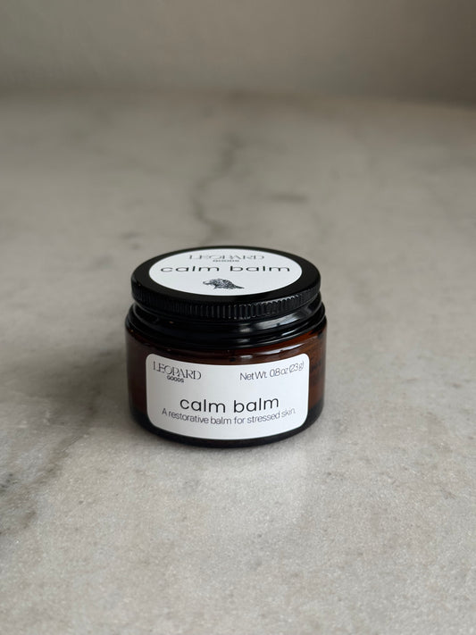 Front label of a 0.8oz jar of Calm Balm by Leopard Wellness on a marble surface