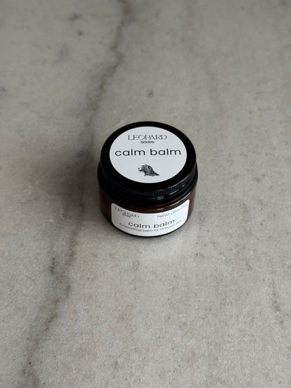 Overhead view of a 0.8oz jar of Calm Balm by Leopard Wellness on a marble surface