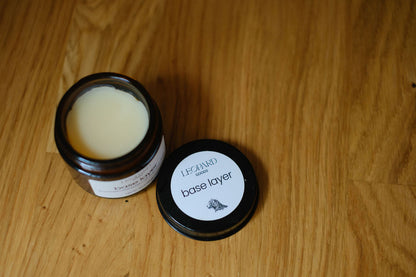 Open jar of Base Layer balm on a wooden surface
