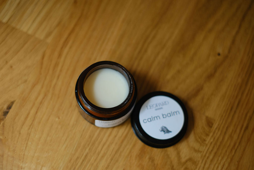 Open jar of Calm Balm on a wooden surface